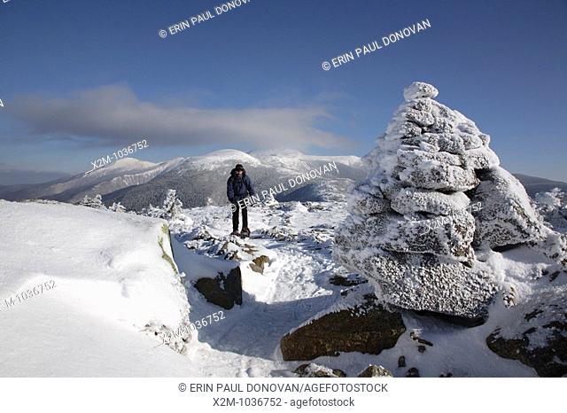 A hiker on the summit of Mount Pierce in the White Mountains, New Hampshire USA  The Presidential Range can be seen in the background