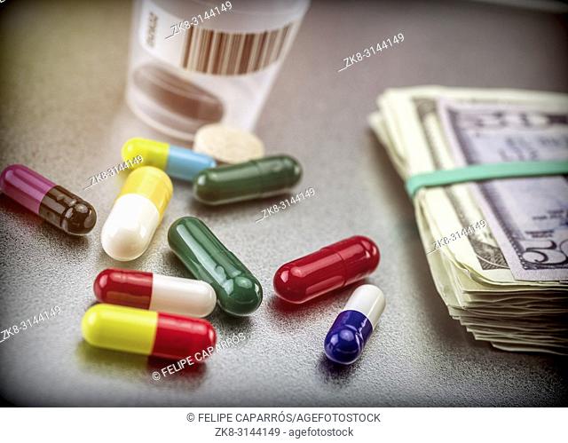 Tablets and capsules of various types next to banknotes Americans, conceptual image of financing health care