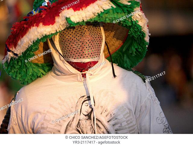 A dancer from Chocaman, Veracruz, wearing a shirt with the image of Our Lady of Guadalupe and wearing a mask, dances the Danza de los Santiagos at the...