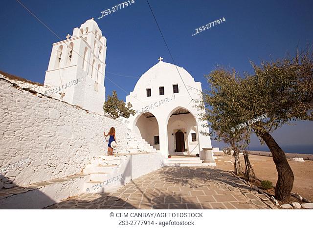 Tourist woman in front of the Panagia Kimissis church by the cliff, Folegandros, Cyclades Islands, Greek Islands, Greece, Europe