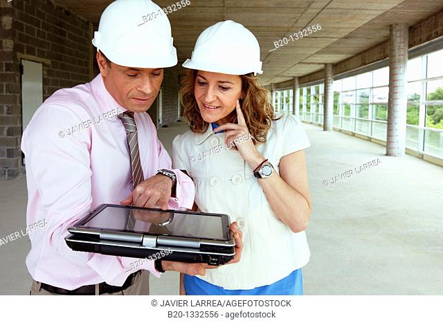 Architect and client with tablet PC in construction site