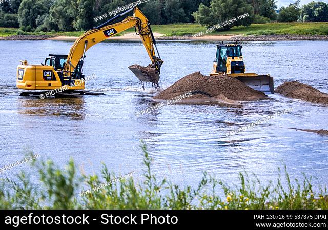 26 July 2023, Lower Saxony, Neu Bleckede: Excavators and bulldozers are used to deepen the access road to the Elbe ferry pier
