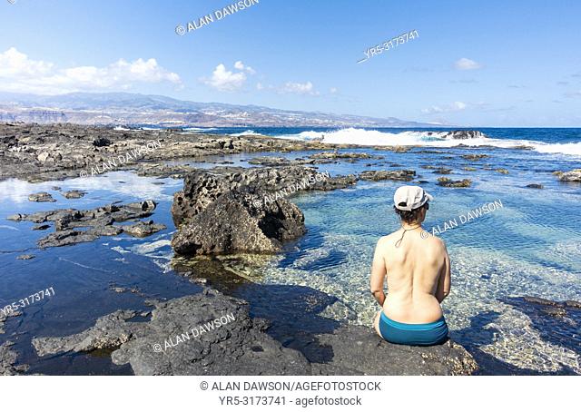 Woman bathing in rockpool at El Confital near Las Palmas on the volcanic north coast of Gran Canaria, Canary Islands, Spain
