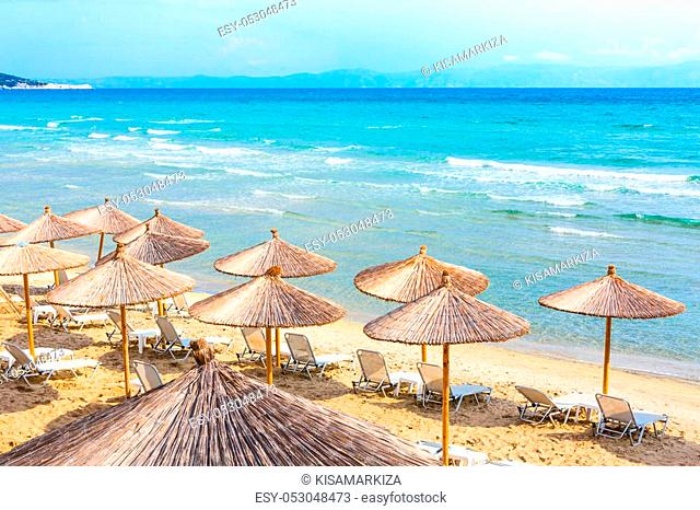 Summer greek beach vacation panoramic background with turquoise sea water waves and umbrellas, Greece