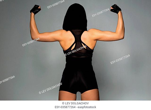 sport, fitness, bodybuilding and people concept - young woman posing and showing muscles in gym