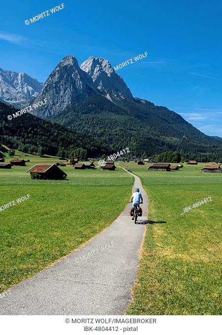 Cyclists on bike tour, cycle path with mountain bike, behind Zugspitze, Tegernauweg, near Grainau, crossing the Alps, Garmisch-Partenkirchen, Upper Bavaria