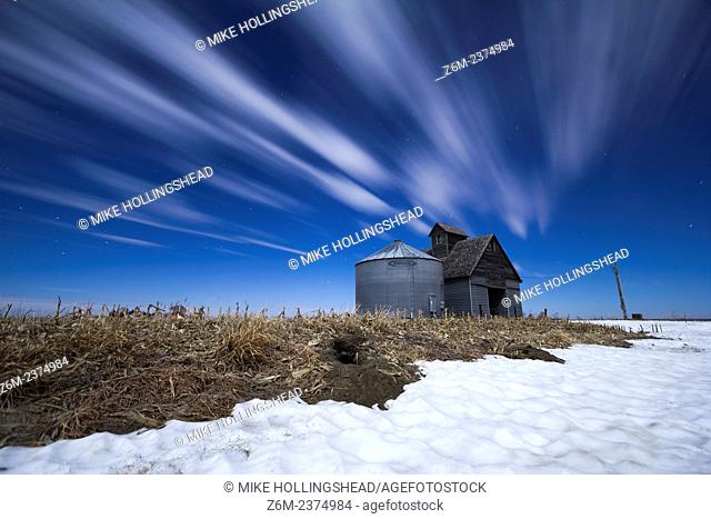 Moon-lit clouds stream over a barn and silo in western Iowa