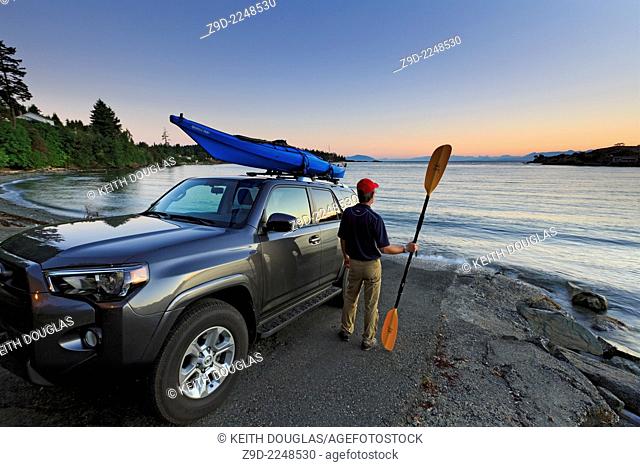 Man getting ready to go sea kayaking, Nanaimo, Vancouver Island, British Columbia