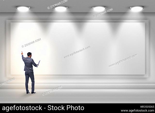 Businessman pressing virtual button on the wall lit with spotlights