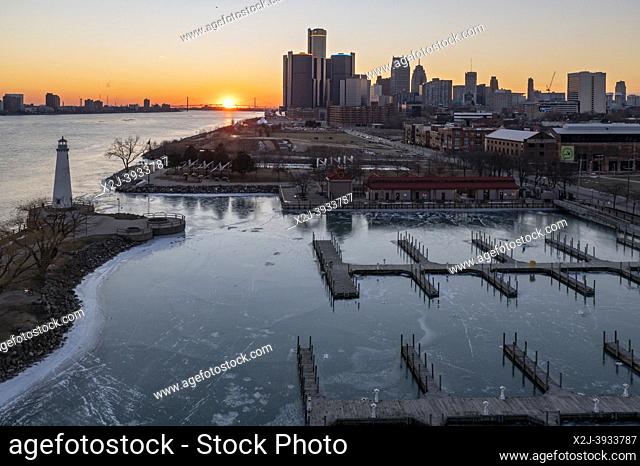 Detroit, Michigan - Downtown Detroit and the Detroit River as the sun sets beyond the Ambassador Bridge. Milliken State Park and Harbor is in the foreground