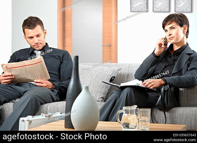 Business people sitting on sofa at office anteroom waiting