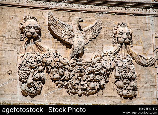Detail of stone ornament of building in front of the Palace of the Popes of Avignon, under a sunny blue sky. Located in the Vaucluse department