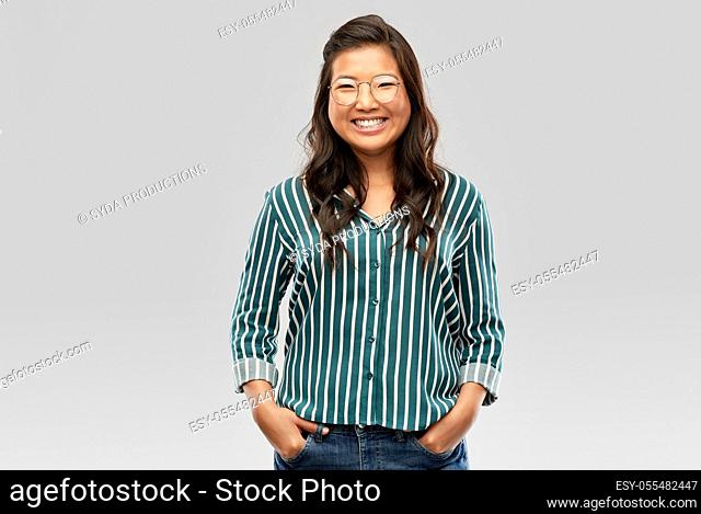 happy asian woman in glasses or student