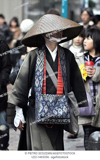 Fukuoka (Japan): a Shinto beggar, crossing a street in Tenjin