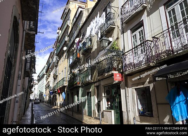 PRODUCTION - 27 October 2023, Portugal, Lissabon: White laundry hangs outside to dry on a washing line in front of a balcony of a residential building in...