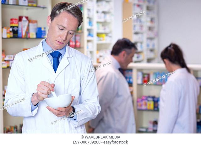 Focused pharmacist using mortar and pestle