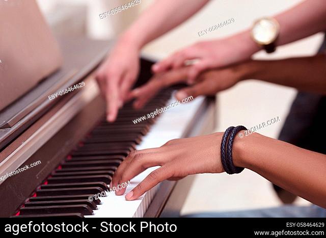 Professional musician playing outdoors. Closeup of keyboard of piano. Man playing piano while lady explaining him something
