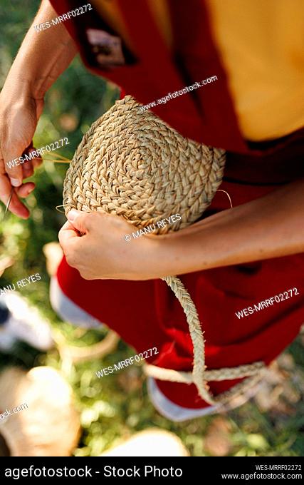 Hands of artisan weaving esparto grass