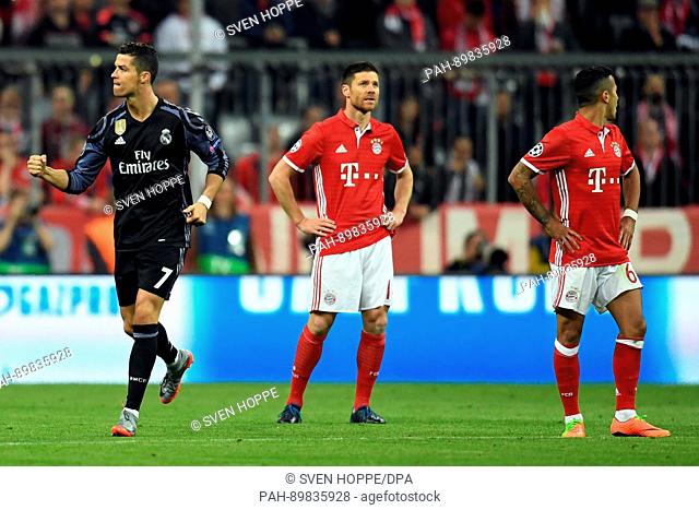 Madrid's Cristiano Ronaldo celebrates his 1:1 goal next to Munich's Xavi Alonso and Thiago Alcantara during the first leg of the Champions League quarter final...