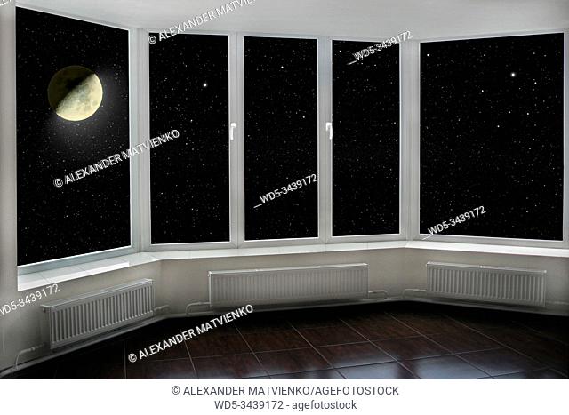 View from window to night sky with stars and shining moon. window with view to Moon and dark night sky. Stars and moon visible from indoor window