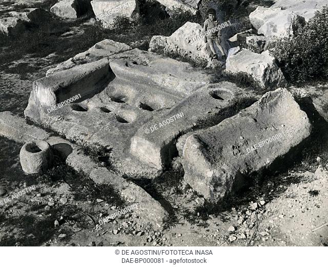 Remains of the tabernacle in the megalithic temple of Tarxien, with holes for vases and votive offerings, Malta, archaeological campaign led by Luigi Maria...