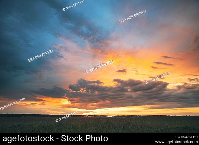 Spring Summer Meadow At Evening Sunset Sunrise. Natural Bright Dramatic Sky In Different Colours Above Countryside Meadow Landscape