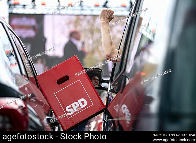 01 May 2021, Brandenburg, Cottbus: At the event of the DGB Südbrandenburg/Lausitz on Labour Day, a man has clamped a cardboard box with the lettering of the SPD...