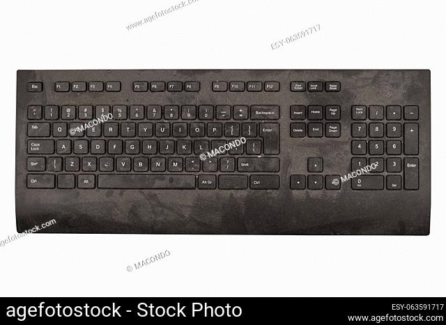 front view closeup of old black keyboard with keys covered in dust and dirt isolated on white background