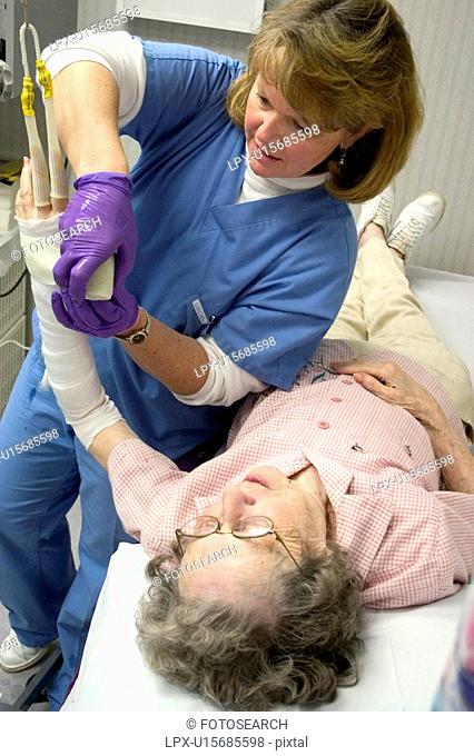 Clinic nurse recasting broken wrist of patient