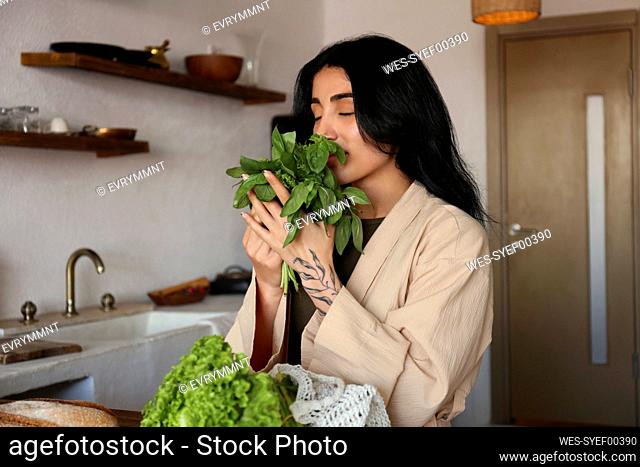 Young woman unpacking groceries on kitchen counter