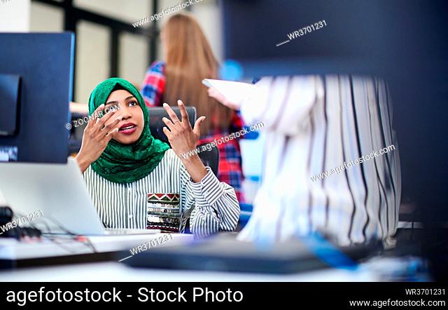 Multiethnic startup business team Arabian woman wearing a hijab on meeting in modern open plan office interior brainstorming