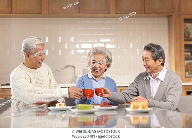 Three friends drinking tea in the kitchen, chinese ethnicity