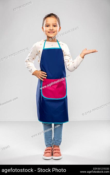 little girl in apron holding something on hand