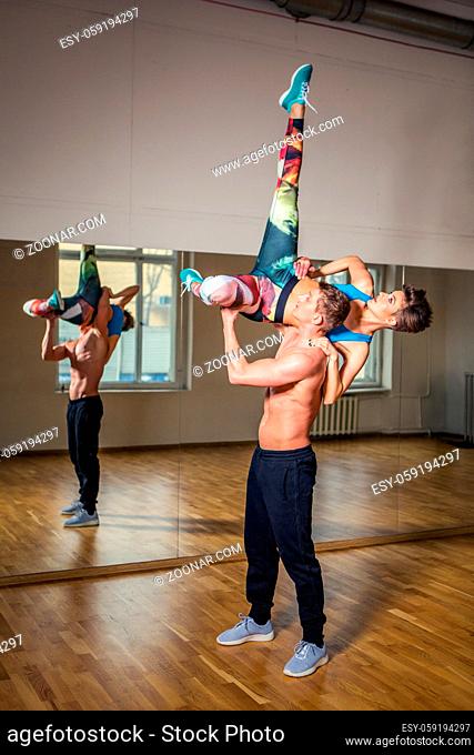 beautiful modern dancers couple practicing in dance studio. mirror room. copy space
