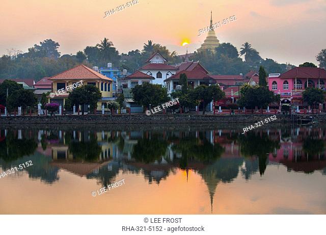 View of Kengtung (Kyaingtong) looking across Naung Tung Lake at sunrise towards the town and gilded stupa of Wat Jong Kham, Kengtung, Shan State