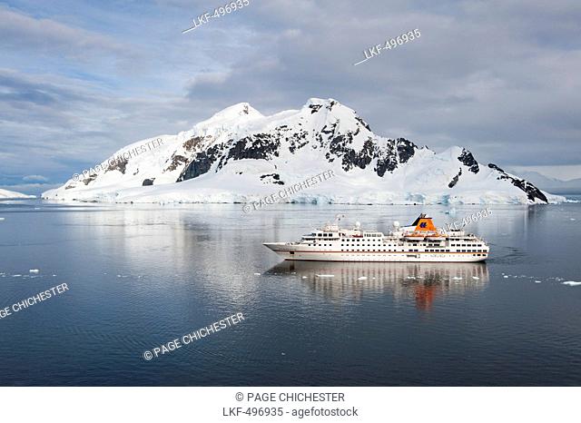 Expedition cruise ship MS Hanseatic Hapag-Lloyd Cruises and ice covered mountains, Lemaire Channel, near Graham Land, Antarctica