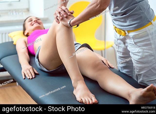 Physical therapist working on knee of woman patient
