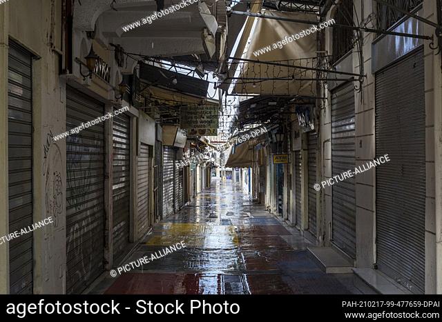 17 February 2021, Greece, Athen: The shutters of the shops in a narrow alley in the Athens district of Monastiraki are closed