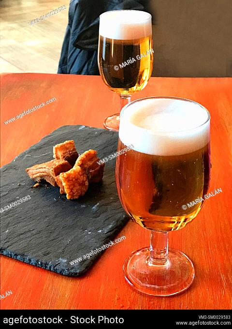 Two glasses of beer with torreznos as tapa. Spain