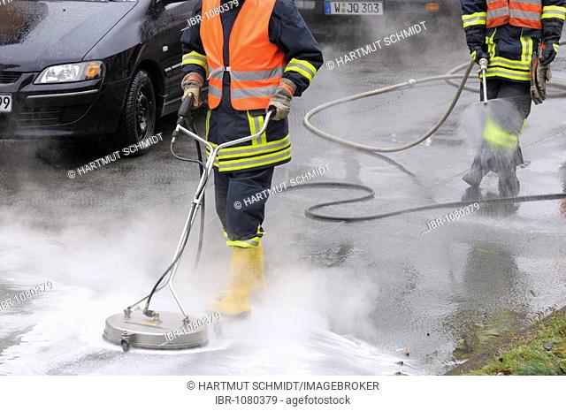 Fire brigade in action, neutralising leaked brake fluid with water