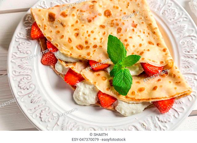 Pancakes with cream and strawberries