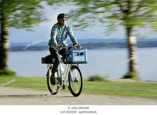 Man cycling with an E-bike along lake Starnberg, Upper Bavaria, Germany