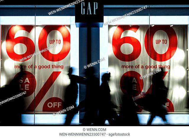 The silhouettes of shoppers as they walk past the Gap Store on London's Oxford Street Featuring: Atmosphere Where: London