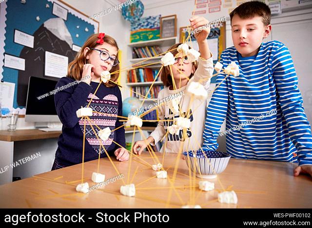 Three children setting up construction during a science lesson