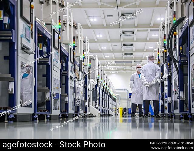 07 December 2022, Saxony, Freiberg: Two employees work in crystal growth at Freiberg-based Compound Materials GmbH. Gallium arsenide wafers for microelectronics...