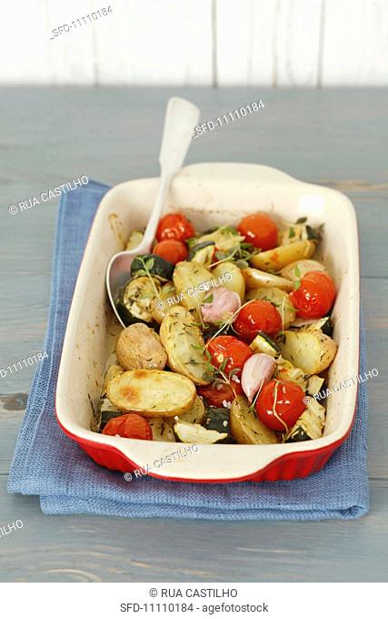 Oven-baked vegetables potatoes, courgettes, shallots, tomatoes