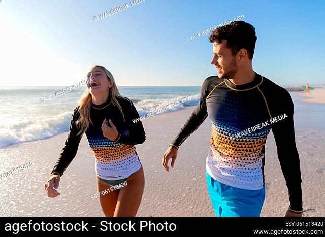 Caucasian couple standing in water at the beach