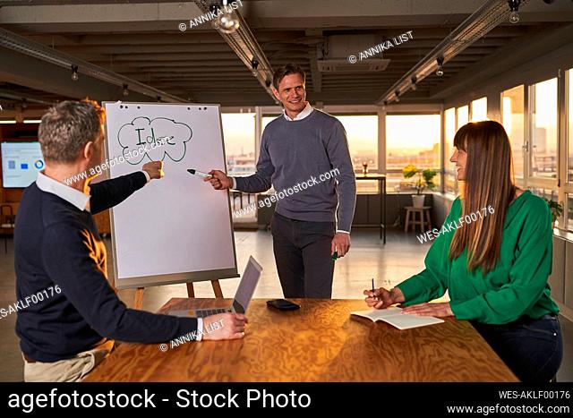 Mature businessman explaining ideas to colleagues in meeting
