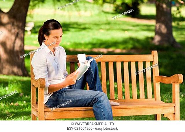 Young woman reading on the bench