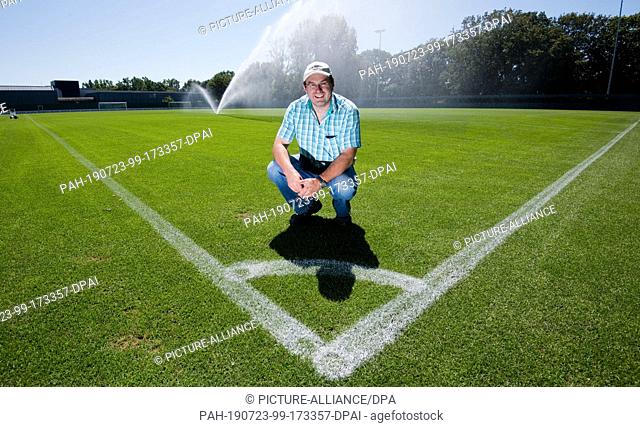 23 July 2019, Lower Saxony, Hanover: Michael Meyer, ""greenkeeper"" at Hannover 96, sits on a training ground. The hot weather also poses special tasks for the...